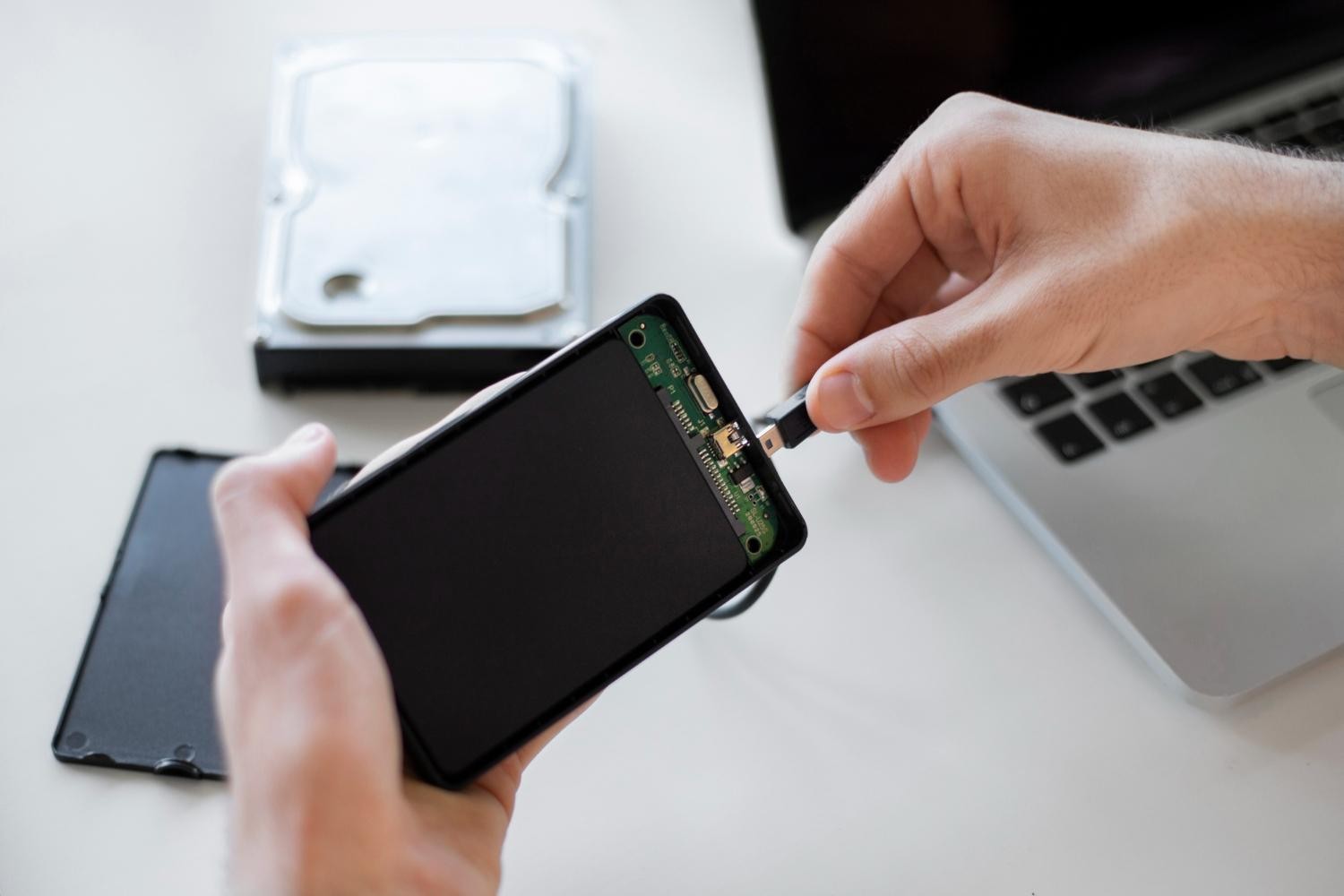 Person connecting external hard drive to laptop computer